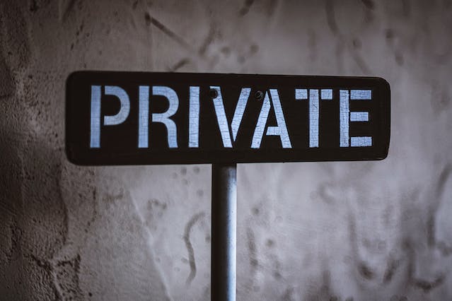 A black and white image of a wooden sign that says, “PRIVATE.”