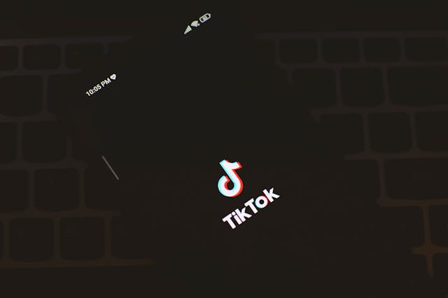 A black phone screen displays the TikTok name and logo.