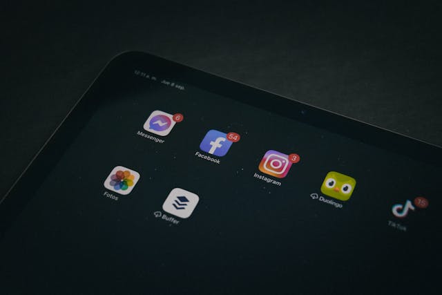 A tablet screen displays various social media app icons with red notifications.