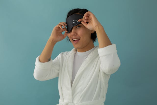 A person lifts their eye mask to take a peek.