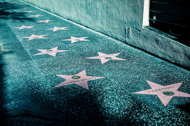 Names of celebrities printed on stars on the Hollywood Walk of Fame.