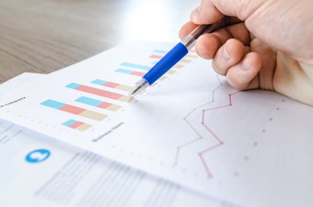 A person studies a bar graph on a piece of paper.