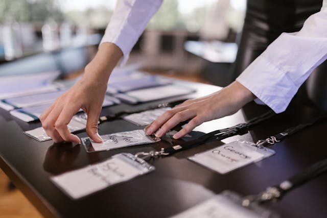 A person arranges name tags on a black table.