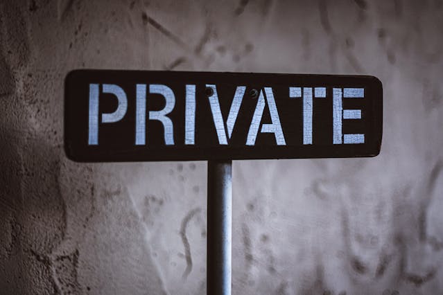 A black and white wooden sign that says, “Private.”