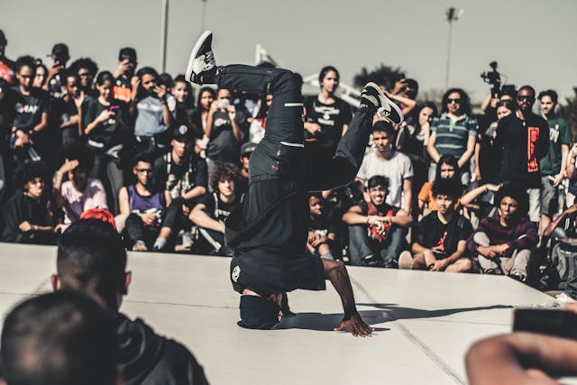 A big crowd gathers around a hip-hop dancer.