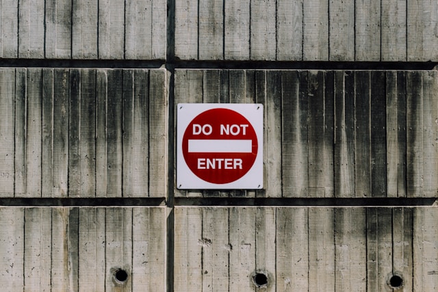 A red and white sign on a wall says, “Do not enter.”