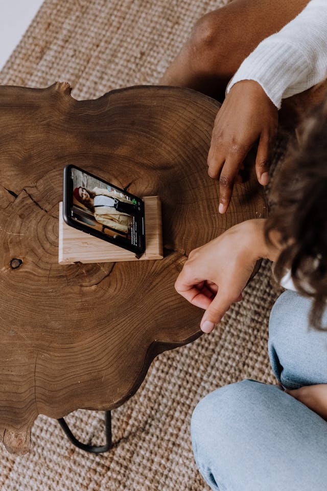 Two friends watch a TikTok video on a stand.