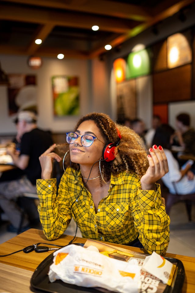 A woman with red headphones hears a sound that she enjoys.