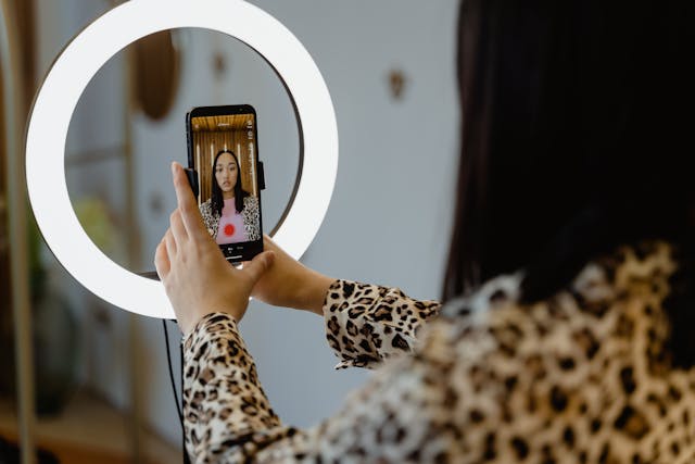 A person records herself for TikTok using her phone.