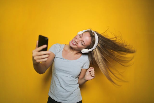 A woman dances while watching a TikTok video.
