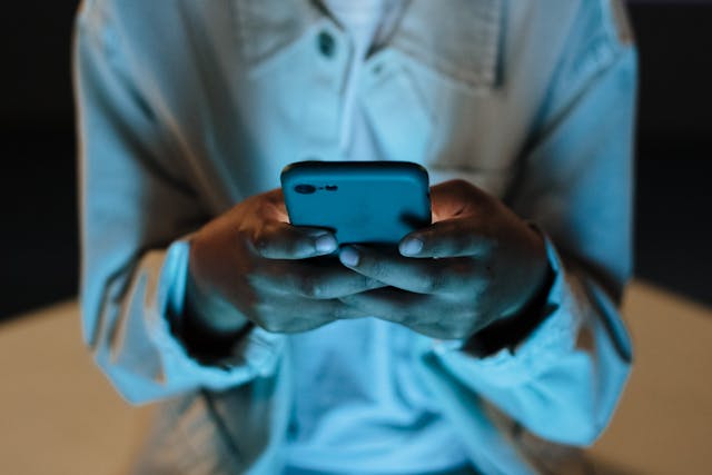 A person holds his phone with two hands.