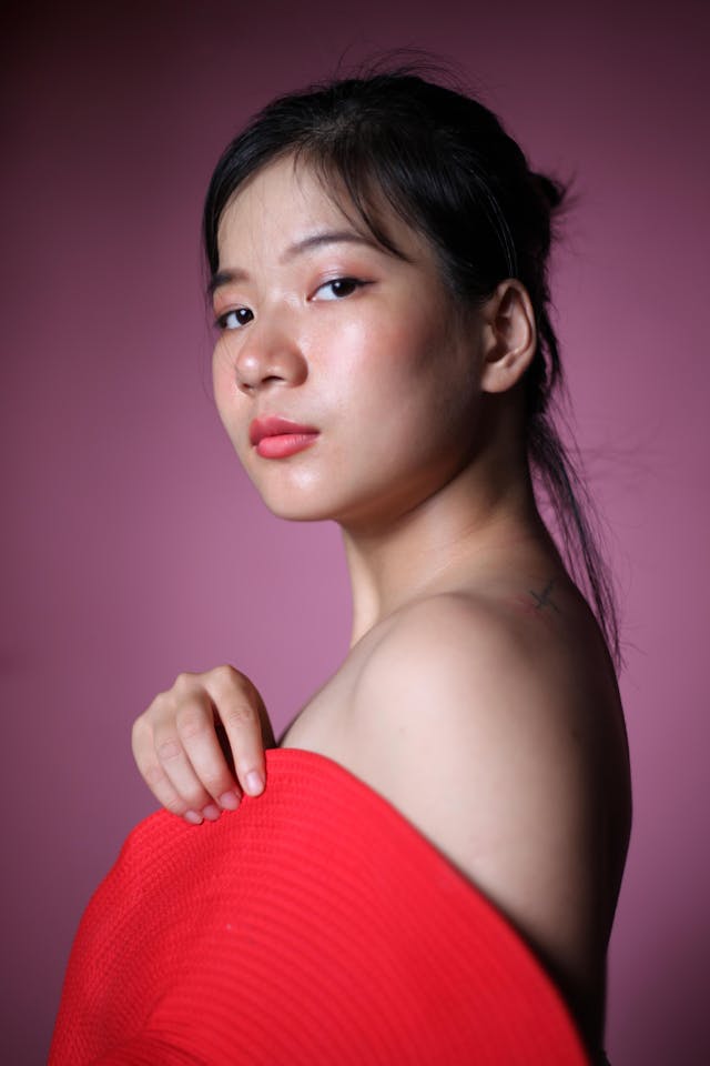 A woman covers her body with a red hat.