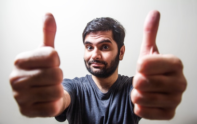 A man gives two thumbs up.