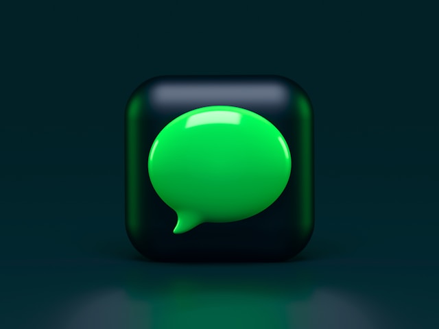 A green chat bubble inside a black cube.