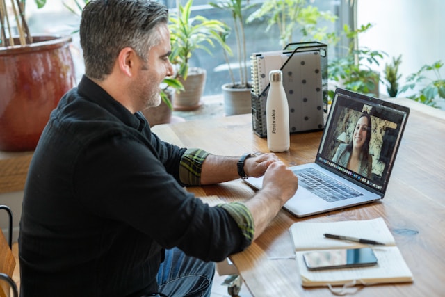 A man sits in front of his laptop while on a video call.