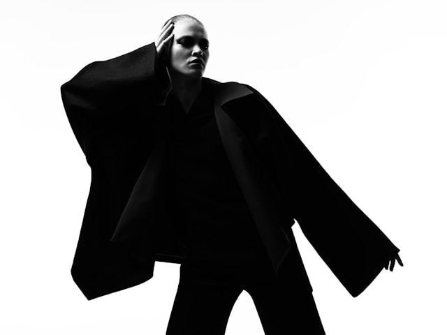 A model in an all-black outfit poses fiercely for the camera.