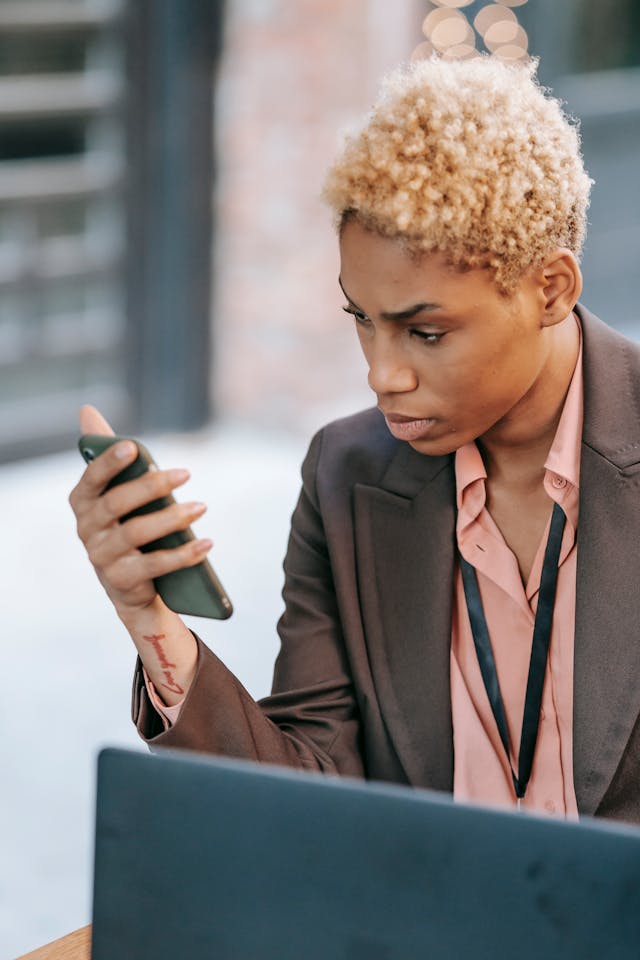 A woman stares at her cell phone.