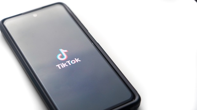 A phone displays the TikTok logo on its screen.