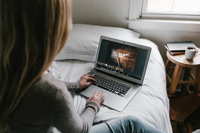 A woman edits a TikTok video on her laptop.