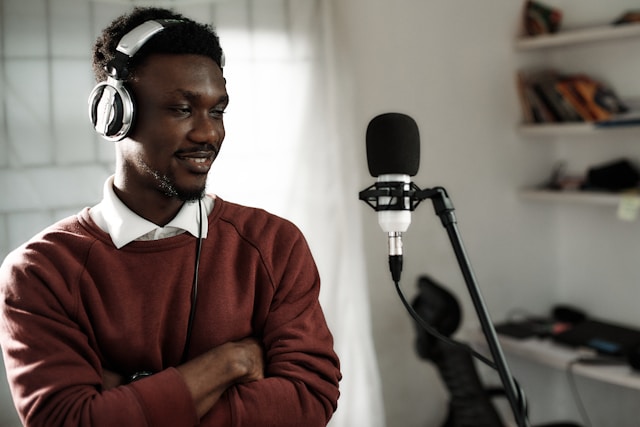 A man wears headphones and sits in front of a microphone for his TikTok video.