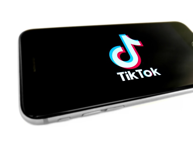 A phone screen displays the TikTok logo.