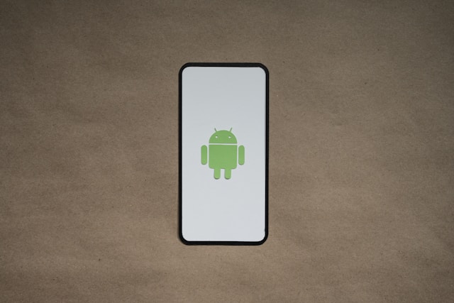 A phone’s white screen shows a green bot icon.