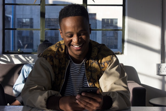 A person laughs while watching TikTok videos on their phone.