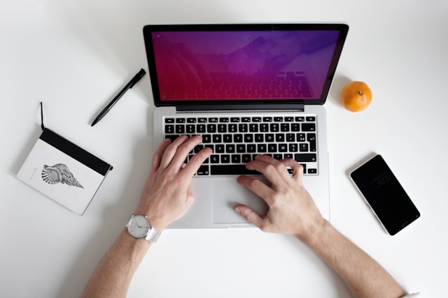 A person uses a laptop to schedule posts on TikTok.