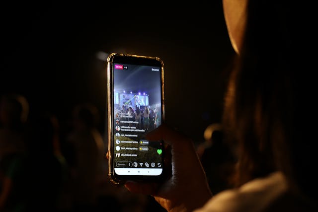 A person records a video of a concert.