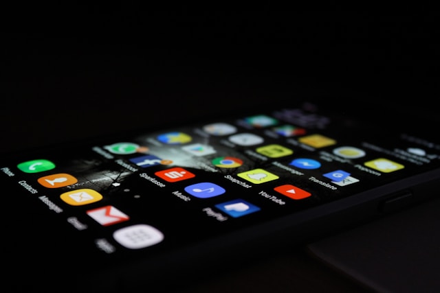 A phone screen displays various social media apps.