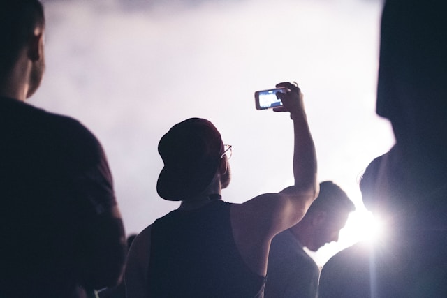 A person holds up his phone to record a video of a concert.