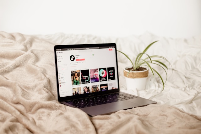 A laptop on a bed displays TikTok’s official profile on TikTok.