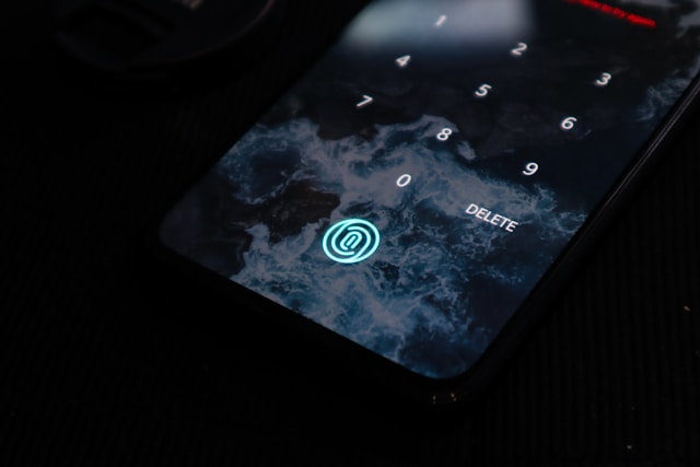 A black phone displays a numeric pad and a fingerprint icon as options to unlock the device.