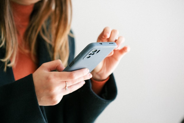 A woman checks TikTok comments on her phone.