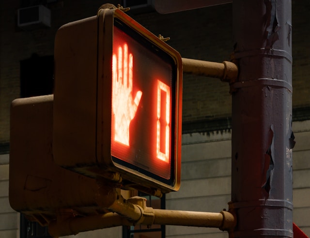 A traffic signal shows a red hand and zero.