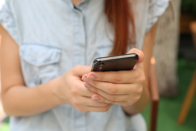 A young woman watches TikToks on her phone.