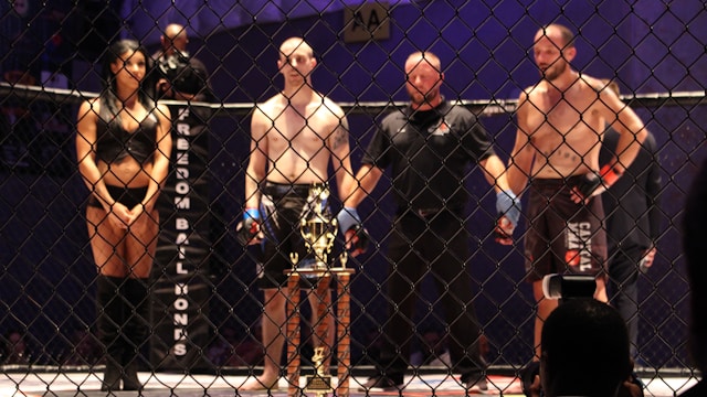 A referee holds the gloved hands of two boxers and gets ready to announce the winner.