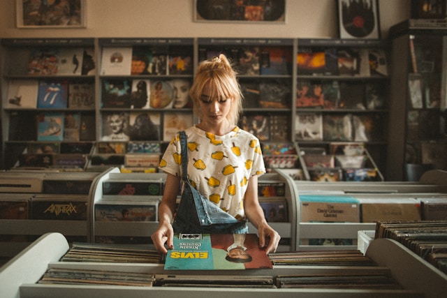 A woman looks through old music records in a music store.
