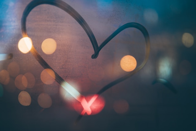 A glass window shows a heart shape traced with a finger.