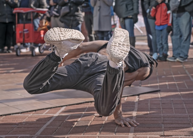 A man breakdances on the street.