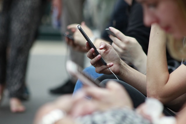 People on a train using their smartphones.