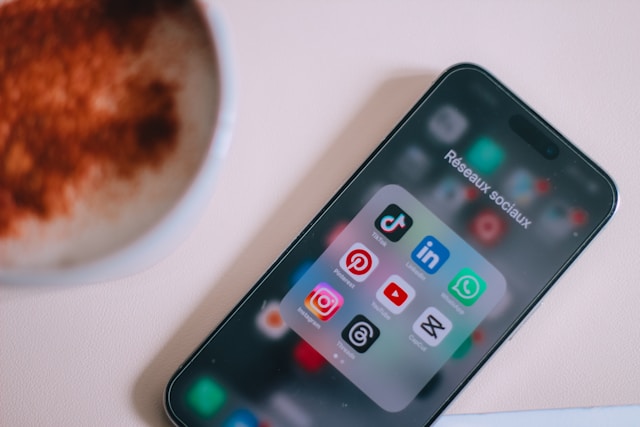 A phone screen displays various popular social media app icons.