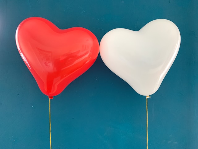 A pair of red and white heart-shaped balloons.