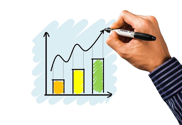 A person draws an upward graph on a whiteboard.