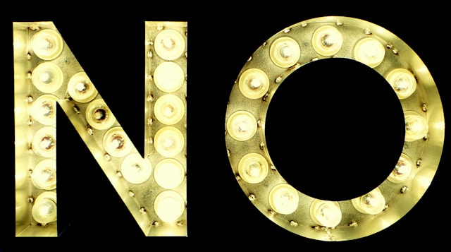 Big letter signs lit with bulbs spell the word “NO.”