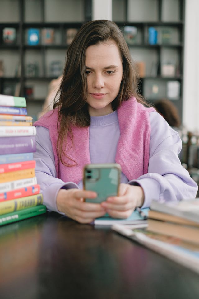 A woman looks at a phone intently.

