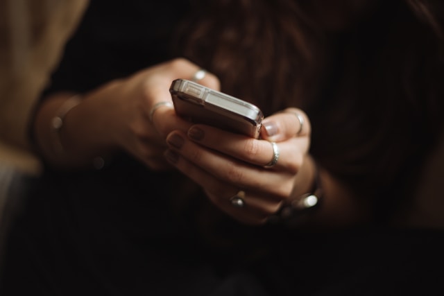 A person sends a direct message on TikTok using their phone.