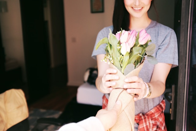 A woman receives a bouquet of flowers.