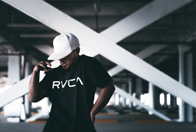 A dancer in a white cap and black shirt records a new dance video for TikTok.