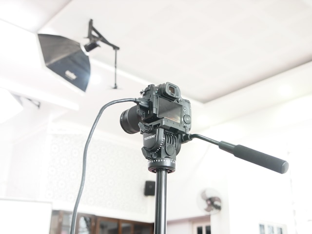 A DSLR camera on a tripod and professional lighting equipment.